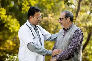 Doctor talking to patient outdoors in a park