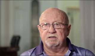 Man with glasses speaking