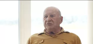 Man talking and wearing yellow shirt